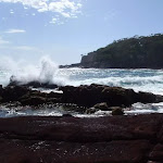 Waves crashing into red sands bay