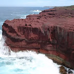 Red cliffs with waves crshing